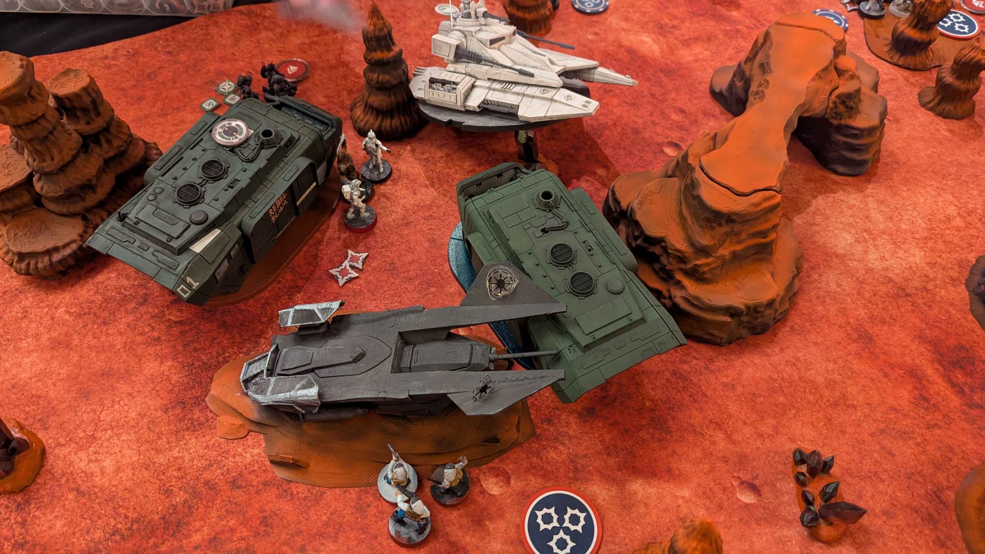 Photo of a game of Star Wars Legion, featuring a Saber Tank and two A-A5 Speeder Trucks.